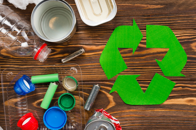recycle-logo-and-various-recyclable-garbage-on-wooden-desk (1)